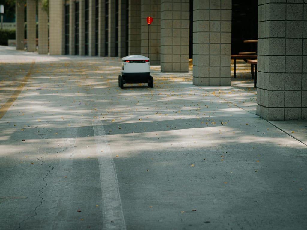 Futuristic autonomous robot on a delivery mission in a modern urban environment.